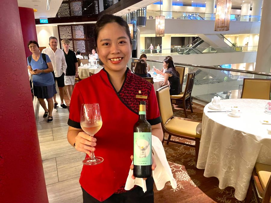 <who>Photo credit: Steve MacNaull/NowMedia Group</who>Server Zoe brings over the Chinese wine at Cantonese restaurant Hai Tien Lo located on the third floor of the Pan Pacific Hotel Singapore.