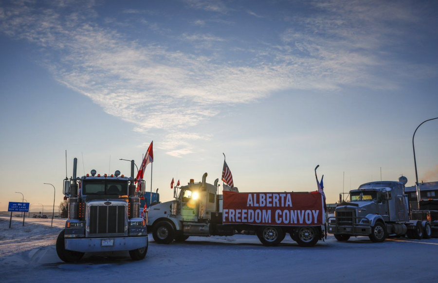 <who> Photo credit: Canadian Press </who> A truck convoy of anti-COVID-19 vaccine mandate demonstrators block the highway at the busy U.S. border crossing in Coutts, Alta., Wednesday, Feb. 2, 2022.